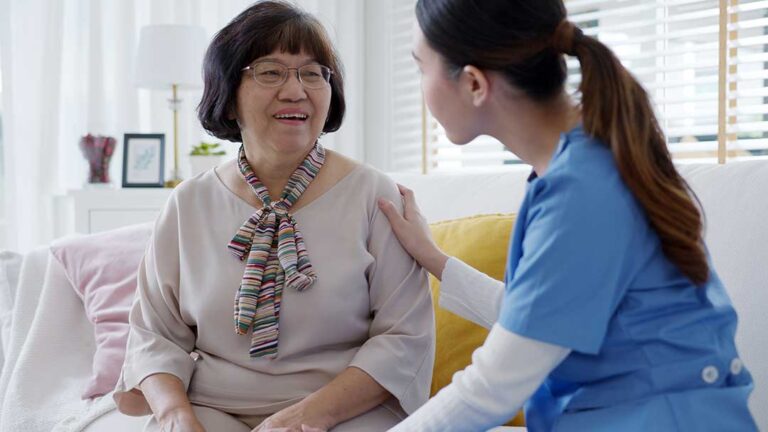 A cozy, personalized assisted living apartment living room with family photos, plants, and a favorite armchair.