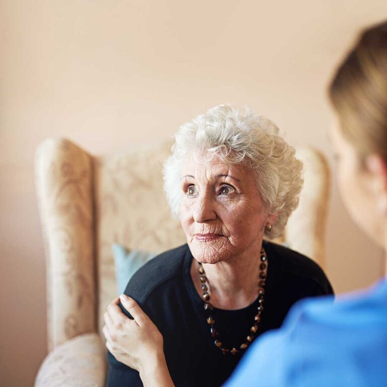 Older adults doing gentle seated exercises in a bright assisted living activity room